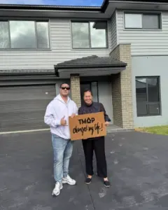 A TMAP family holding their TMAP doormat