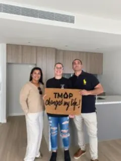A TMAP family holding their TMAP doormat